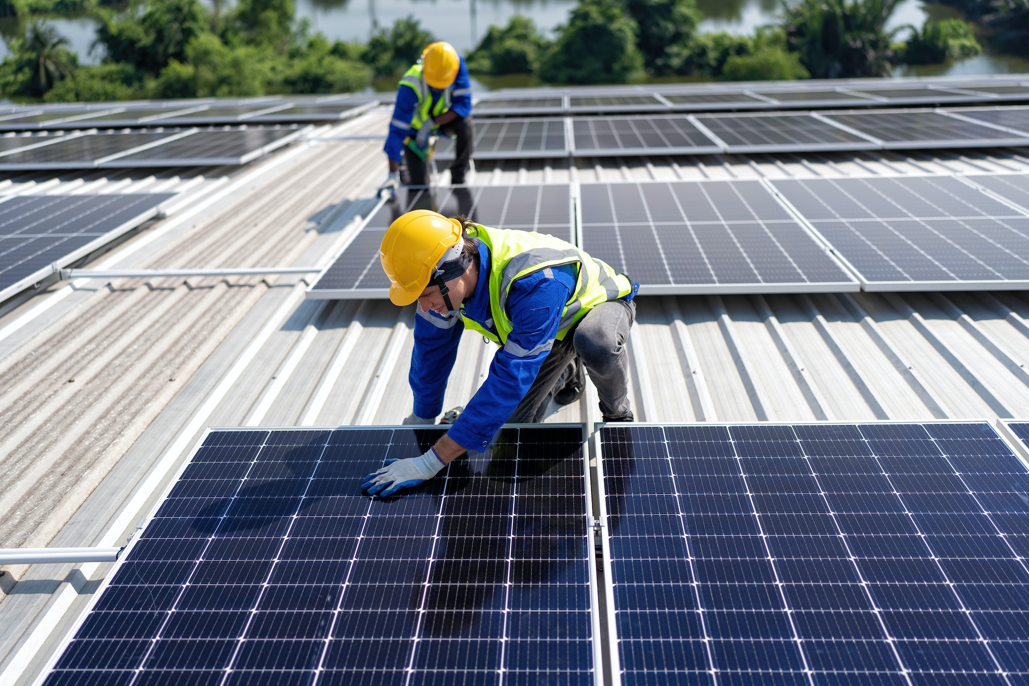 engineer-on-rooftop-kneeling-next-to-solar-panels-photo-voltaic-with-tool-in-hand-for-installation.jpg